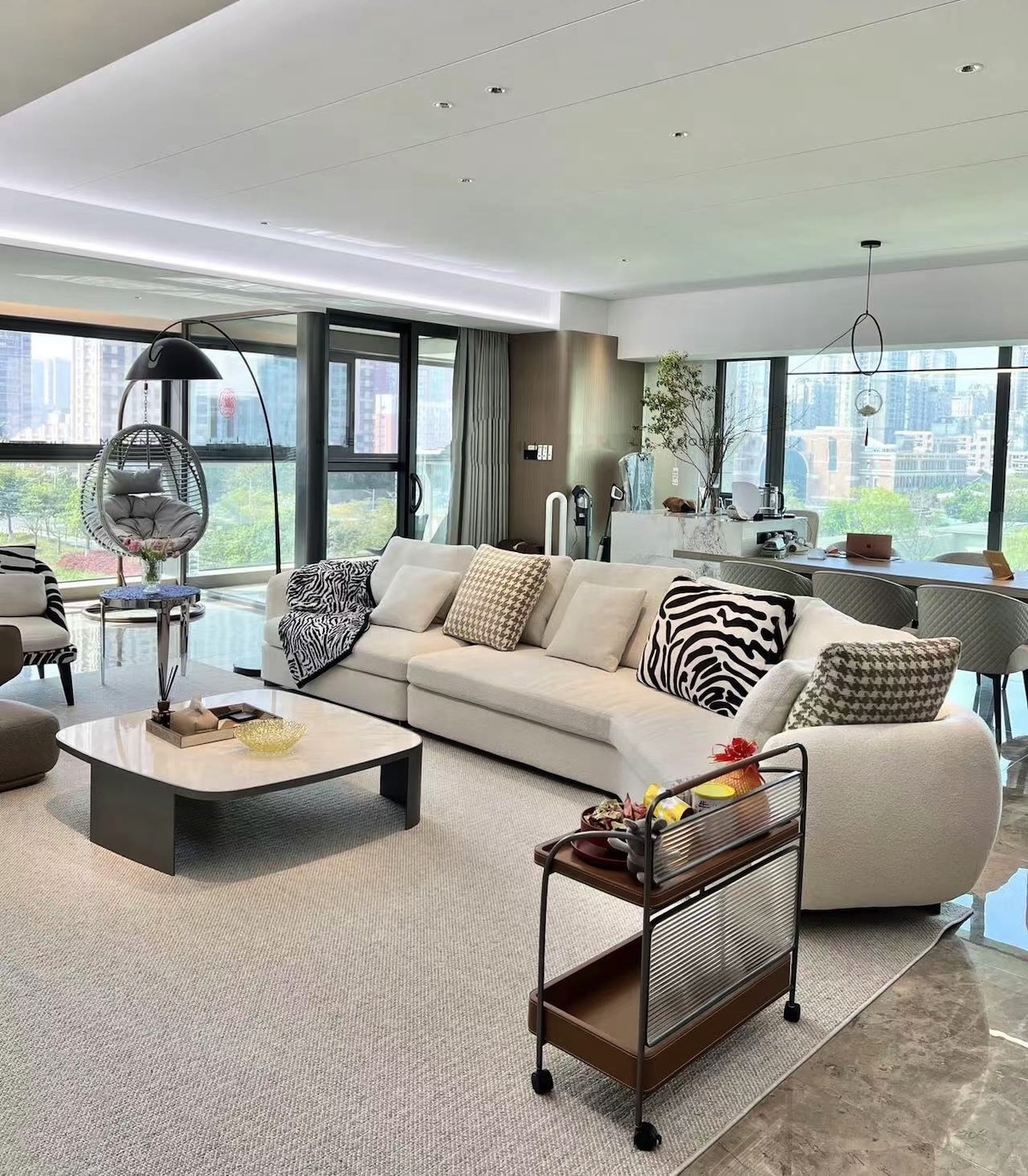 Editorial penthouse living room with curved modular sofa and city views