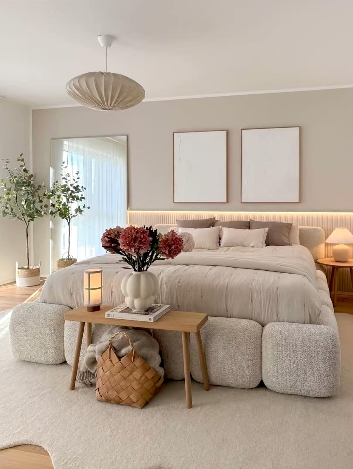 Minimalist primary bedroom with bouclé modular bed and fluted wood paneling