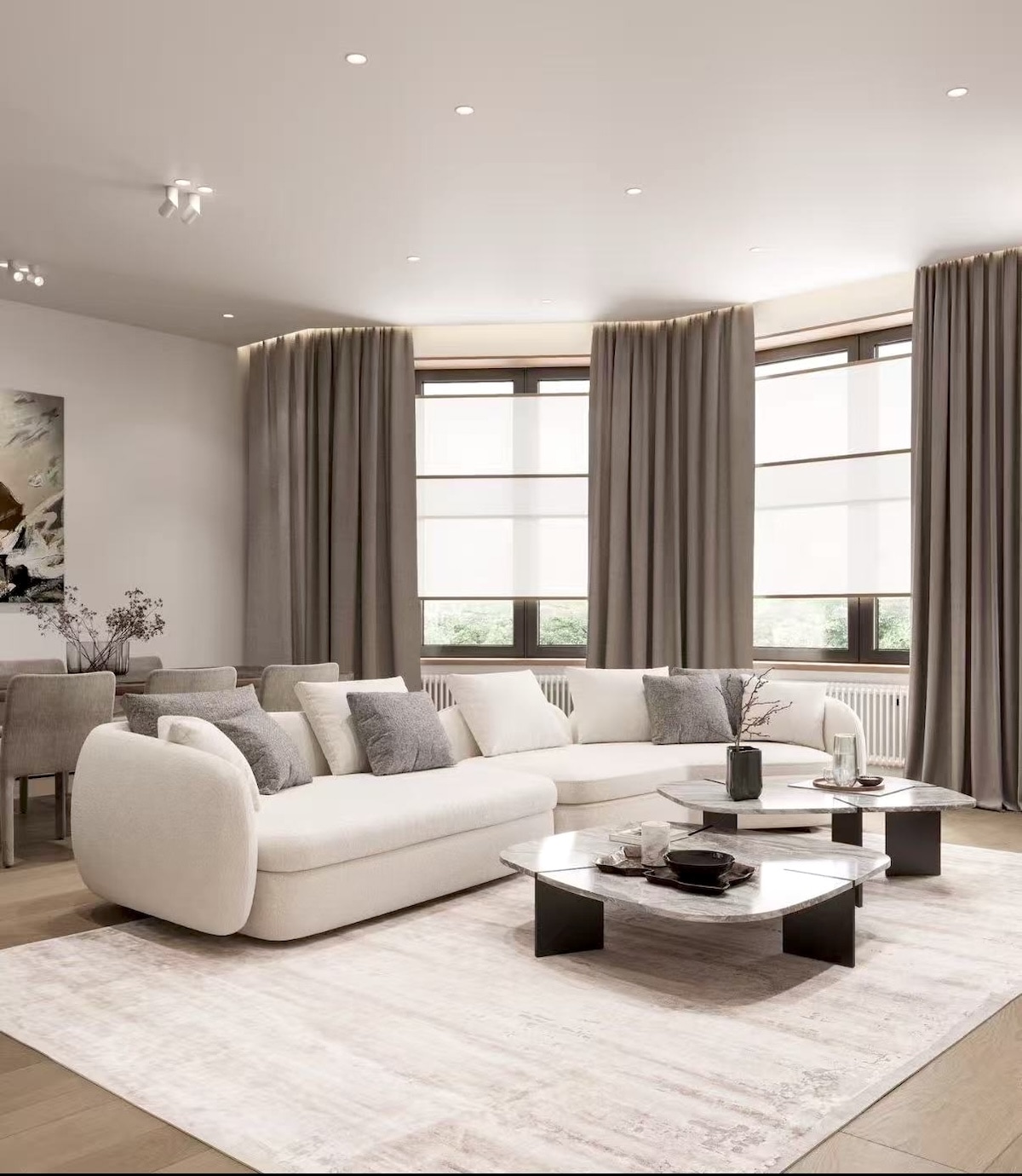 Neutral open-plan living room with modular sectional and marble coffee tables